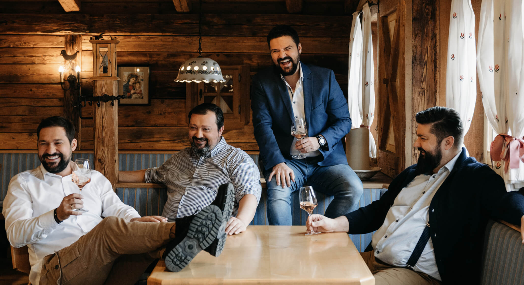 Anton, Michael, Klemens und Lukas sitzen im Heurigen und trinken Wein