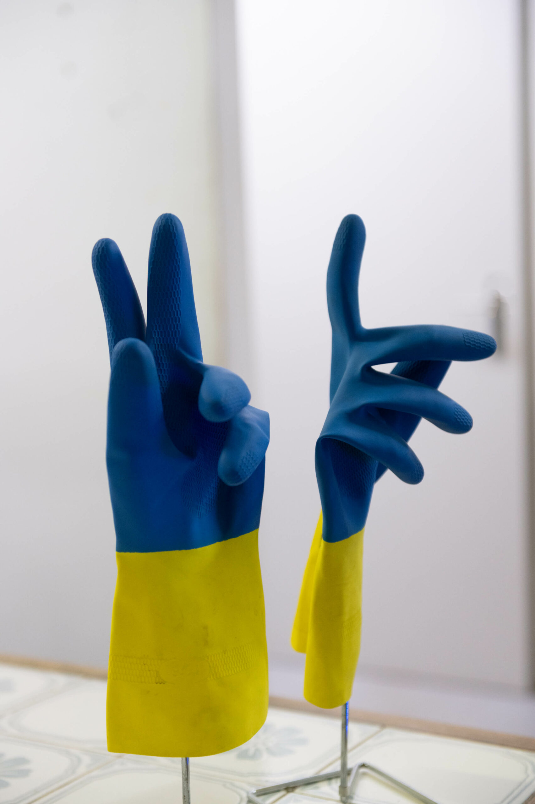Blau gelbe Handschuhe in auf einem Handschuhständer