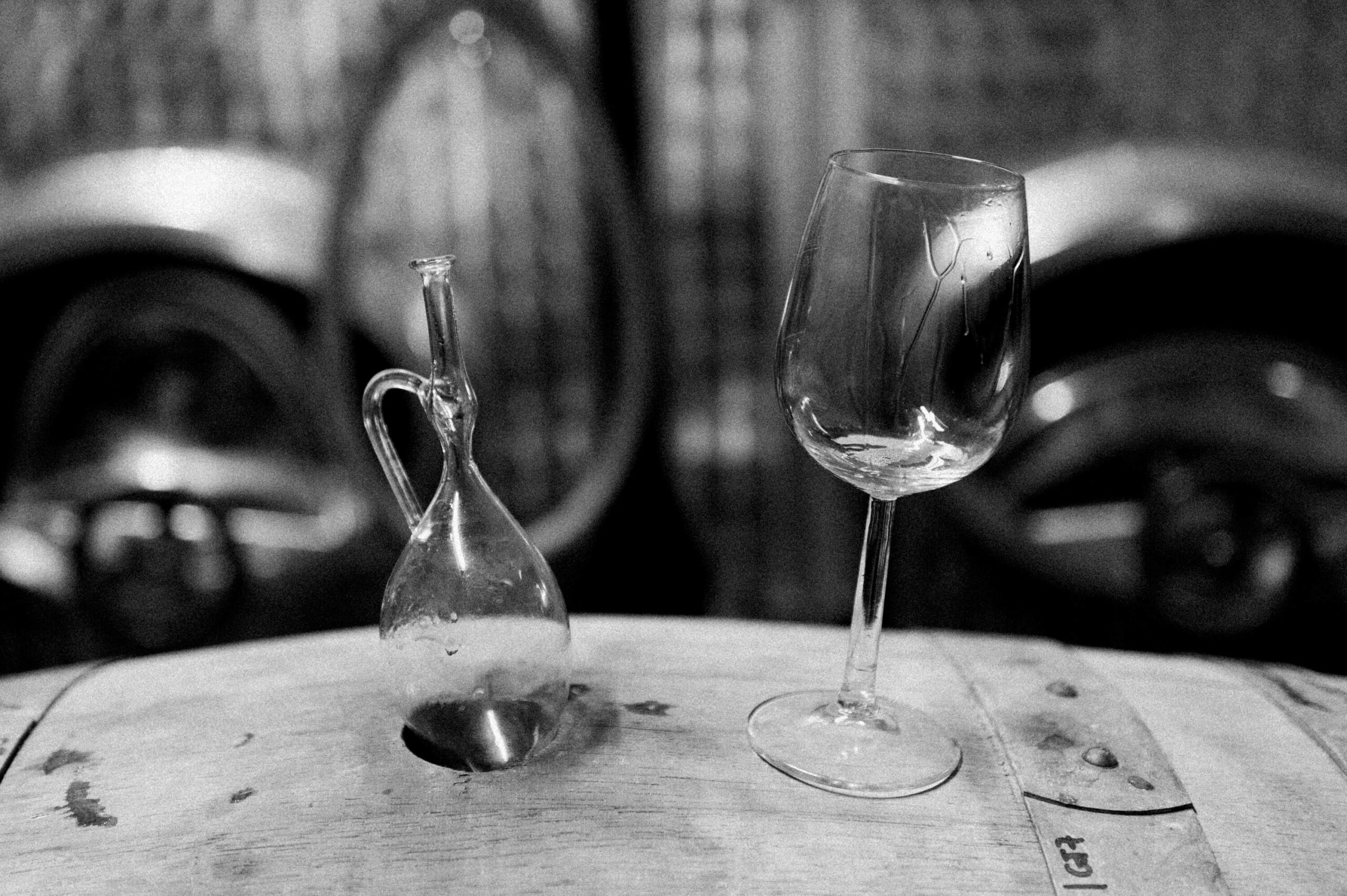 Weinglas auf einem Weinfass in schwarz weiß