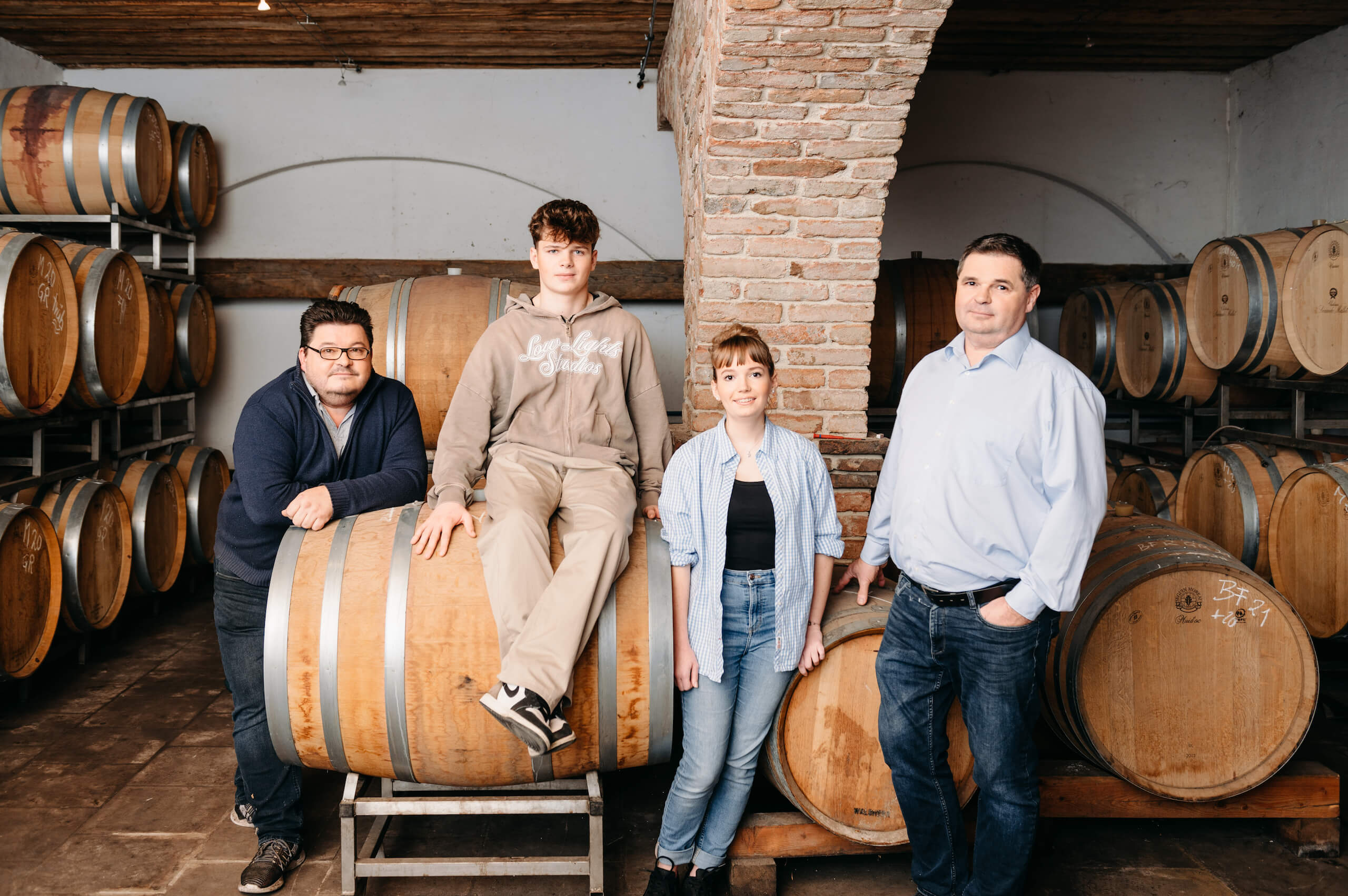 Familie Waldherr im Weinkeller mit den Fässern im Hintergrund